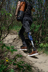 穿黑色牛仔裤和T恤衫 随身带垫子的男子在山上旅行假肢截肢者活动技术膝盖动机男性男人冒险截肢图片