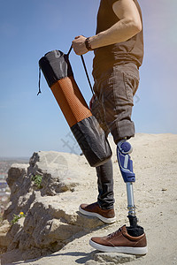 穿黑色牛仔裤和T恤衫 随身带垫子的男子在山上旅行活动男人技术截肢者男性动机冒险膝盖截肢假肢图片
