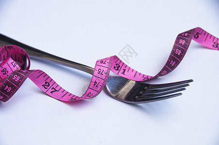 白色背景上带叉子的测量磁带 重量损失概念图片