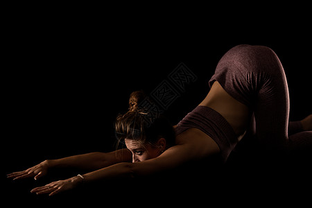 练瑜伽的合适女人 半个双光月女孩在工作室里做黑人背景的锻炼女士力量活动体操享受运动员姿势冥想运动装平衡图片