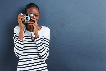 笑一个有魅力的年轻女人 用旧相机拍照的照片被拍到图片