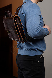 穿着蓝色毛衣的背包和棕色皮背包 单性袋出售手提箱奢华书包吊带男人皮革办公室行李口袋文件夹图片