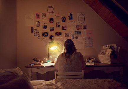 一个年轻女人晚上在卧室里用笔记本电脑的回视镜头被拍到 然后她又回到了床上图片