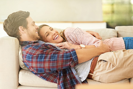 一对快乐的年轻夫妇在家沙发上放松一阵子 被拍到了图片