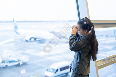 可爱的小女孩看着机场的一架飞机 笑声婴儿旅行旅游游客女士拥抱孩子假期窗户孩子们图片