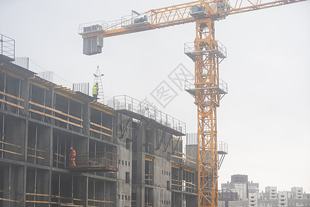 正在建造大型住宅塔楼 有黄色大起重机背景图片