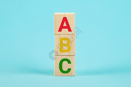 木块上的 ABC 木制立方体块上的 Abc 字母字母表以蓝色背景上的柱子形式 学习外语 英语初学者 复制空间图片
