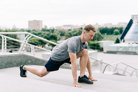 年轻健身运动员在运动前伸展双腿 然后在城市街道户外跑动健康生活方式和体育概念男性休息活力建筑城市耳机男人跑步福利有氧运动图片