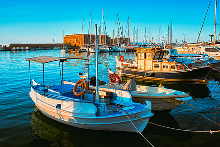 希腊克里特岛希腊希拉克利翁的威尼斯堡和停泊渔船港口码头海岸日落背景建筑血管城市钓鱼堡垒图片