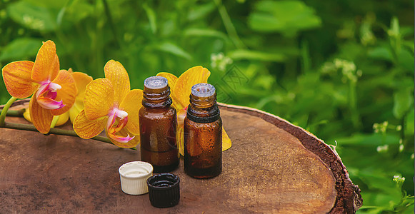 用黄色兰花和天然油 来按摩石油和石头岩石香水背景瓶子香气植物群化妆品药品疗法玻璃图片