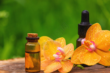 白底隔绝的碗中含有基本油和兰花的瓶子产品奢华治疗香气护理植物群香味化妆品身体疗法图片