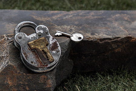 古老的铁链锁 钥匙在绿草原上的巨石上岩石古董工具金属静物腐蚀锁孔石头安全黄铜图片