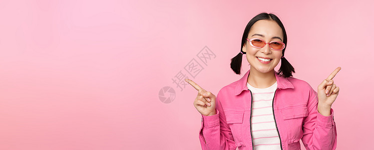 选择 时尚的韩国女孩 亚洲女模特手指侧身 展示两种变体 产品广告 展示物品 站在粉红色背景上办公室黑发工作室促销情感困惑女士大学背景图片