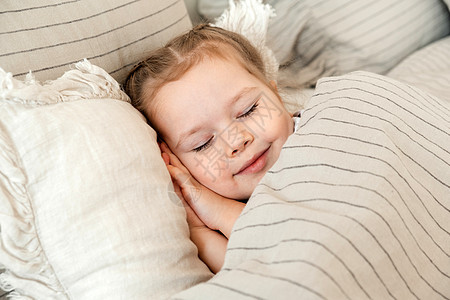 迷人的小女孩睡在床上 小金发在铺着白色床单的床上甜甜地睡着 文本的地方 健康的孩子图片
