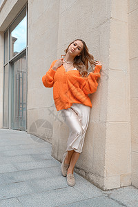 穿着橙色毛衣和在街上露面的米粉服装的时装妇女肖像微笑金发情感橙子头发女士珠宝乐趣街道喜悦图片