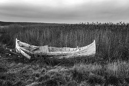 一只废弃的旧木头渔船 在海滩上 黑白图片