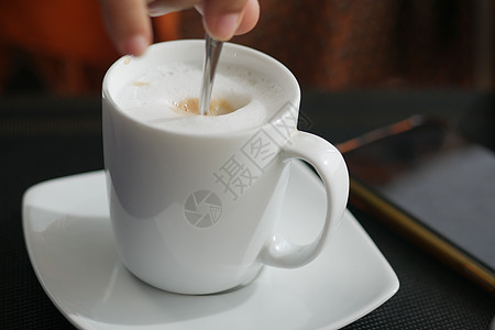 背包行走的人用勺子来搅拌咖啡的人牛奶咖啡店黑色咖啡杯艺术性背景