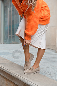 穿着橙色毛衣和在街上露面的米粉服装的时装妇女肖像橙子压痛女孩情感诱惑裙子金发女性喜悦成人图片