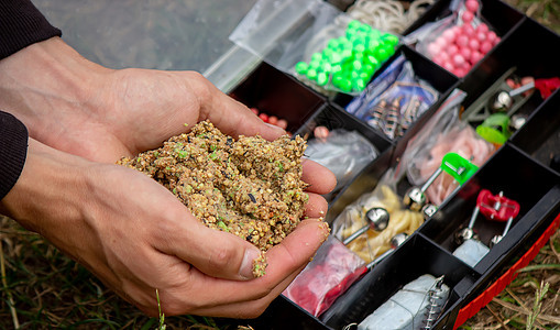 具有山地背景和有选择性重点的木制浮板上的捕捞渔具纺纱食物卷轴淡水蠕虫男人运动盒子补给品垂钓者图片