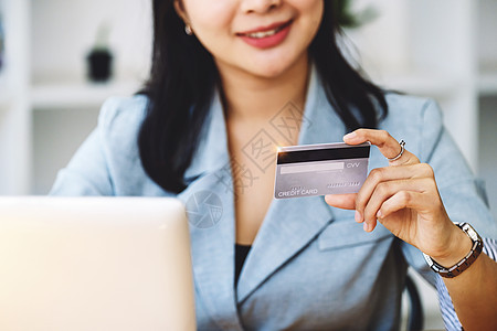 在线购物和互联网支付 亚洲女性正在使用信用卡和笔记本电脑在线购物或在数字世界中处理差事图片