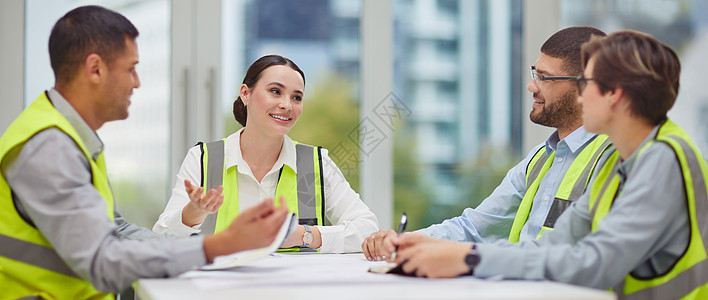 让我们谈谈建设 一群年轻建筑工人在会议期间坐在会议室桌子旁的裁剪镜头图片