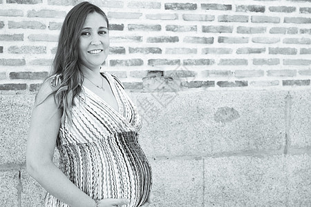 身着多色条纹衣服的7个月的户外孕妇幸福家庭女士婴儿怀孕女孩肚子连衣裙母亲腹部图片