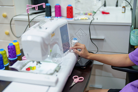 刺绣 手工艺品 爱好 中小企业业务 家族企业 亚洲女性设计师的肖像正在根据客户订单使用自动刺绣机设计图案命令商业店铺职业包装仓库图片