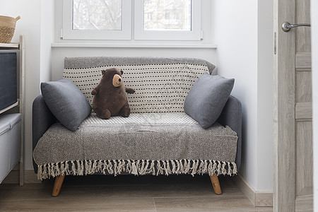 2个枕头的灰色软沙发 70式现代设计沙发 在一个小空房间窗户附近图片
