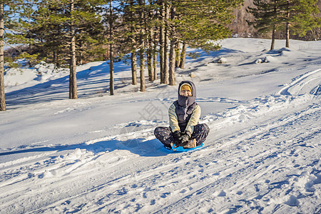快乐的女子在滑雪上滚下山坡时玩得开心 冬季运动 有雪雪 人们骑着雪橇微笑女士闲暇滚动活动娱乐喜悦中年女性旅行图片