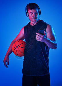 有些音乐正是我需要的 专注点 蓝色过滤镜头 一个运动员戴着耳机边打篮球时穿戴耳机图片