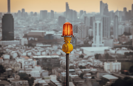 高层建筑屋顶安装的红色障碍灯灯笼 确保飞行安全 并在城市景观背景下警告飞机的危险天空技术电气设备交通高楼建筑日落导航警报图片