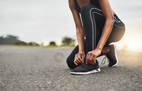 跑得越快越好 一个运动的女人在户外锻炼时绑着鞋带的近镜头图片