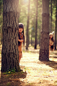 自然是我们传统的一部分 两个小女孩的肖像躲在树后面 同时在树林里装扮成衣服图片
