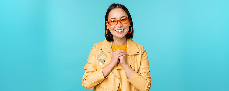看着有希望 受宠若惊 笑笑快乐 站在蓝底脸色的亚洲女性形象工作女孩情感广告太阳镜微笑学生办公室促销工作室图片