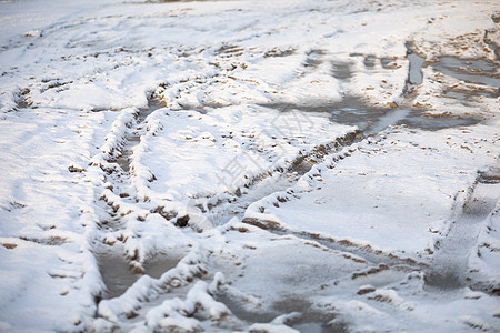 被雪覆盖的泥土路上的汽车翻转痕迹图片