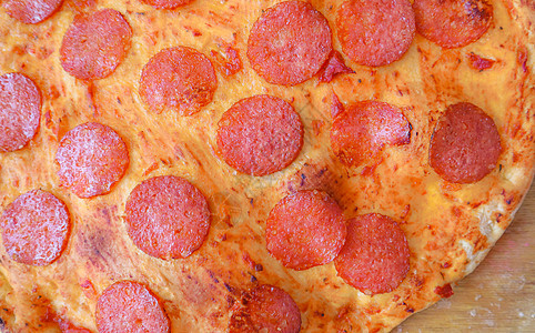 美味辣椒比萨饼的背景     木板上披萨部分的宏观摄影图片