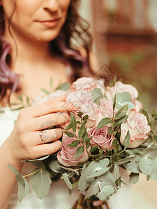 穿着新娘的裙子站在绿色花园里 拿着一束盛满鲜花和绿麦效应的婚礼花束乡村女士女性装饰女孩夫妻牡丹庆典植物花圈图片