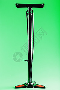 绿色背景下用于泵车轮的黑色自行车手动气泵图片