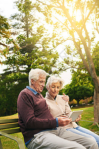 和这几代人一样 在公园里用数字平板电脑拍一对老夫妇的镜头图片