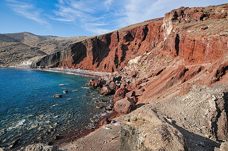 在希腊圣托里尼岛红海滩火山灰沙岩层上观看支撑旅行石头海景地标火山口卵石海岸蓝色悬崖图片