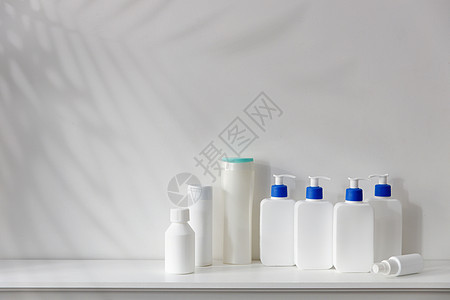 白色瓶子 有蓝色的撒泡液 洗发水 调味剂 奶油和液体肥皂 放在卫生间架子上图片