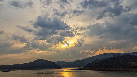 山丘之间湖的景色闪耀着太阳反光图片