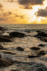 岩石海滩上美丽的日落太阳戏剧性阳光地平线海岸线晴天蓝色海岸海景云景图片