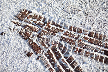 城市人行道上软雪上的新鲜轮胎痕迹图片