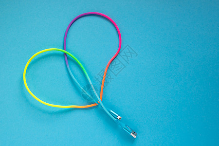 多彩彩虹USB电缆 蓝色背景的智能手机图片