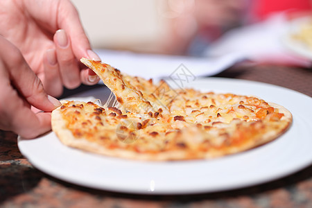 女性的手撕下开胃热切的披萨片和芝士紧贴图片