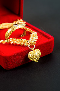 金项链和心脏形状 黑色的红色天鹅绒盒里有金环图片