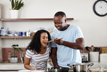 谁的厨艺更好 一对年轻夫妇在家里的厨房里一起做饭的镜头图片