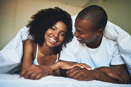 一对快乐的年轻夫妇在卧室的卧底下 放松下来的肖像 我从不觉得自己是幸福的图片