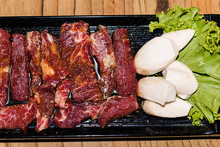 韩国传统风格的新鲜猪肉牛肉肚子BBQ肋骨烹饪炙烤食物烧烤盘子菜单自助餐蔬菜美食图片